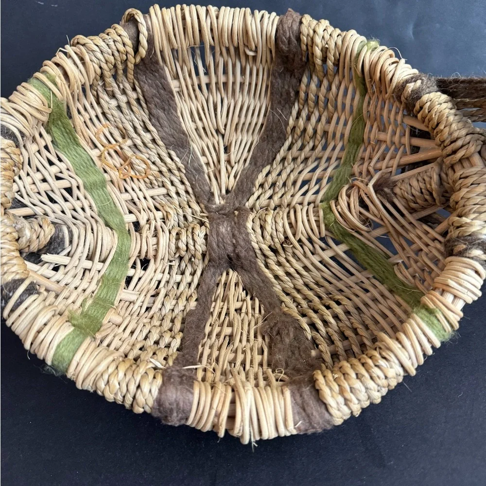 Vintage handwoven basket with brown and green yarn details and eye of God.
